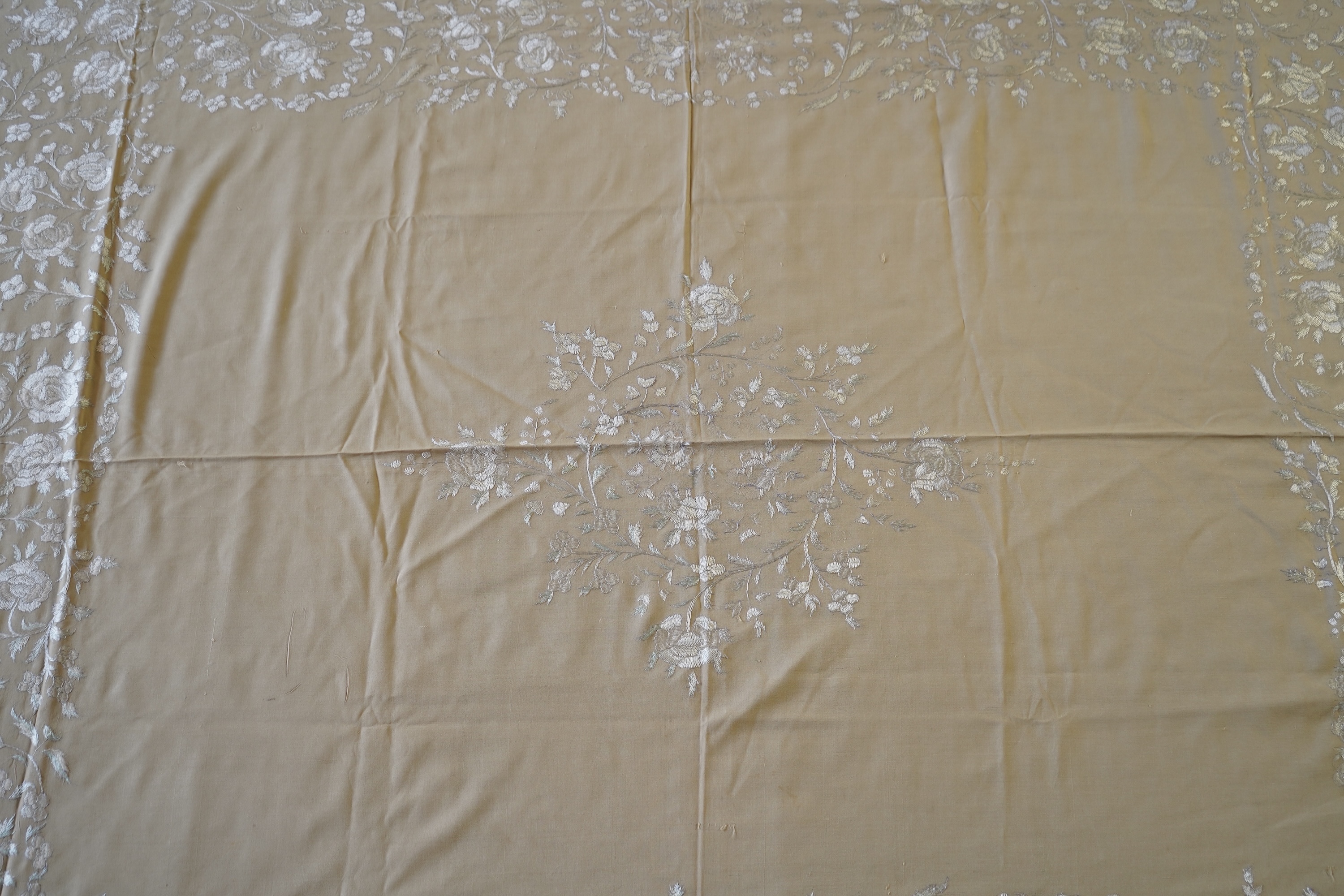 A 1920’s heavy shantung silk hand embroidered table cover. Worked with decorative rows of button hole stitch. Embroidered with white, green and blue silk flowers. 240cm x 204cm. Condition - some fine holes near corners,
